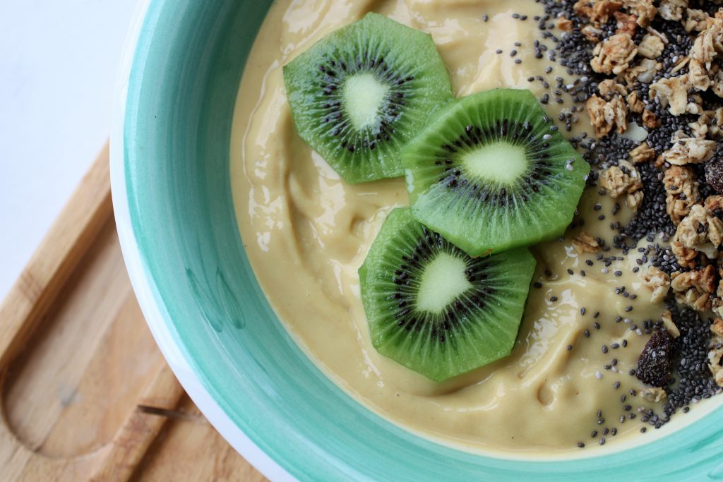 mango and vanilla smoothie bowl topped with kiwi 