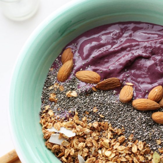 cherry and vanilla smoothie bowl topped with nuts, granola and seeds