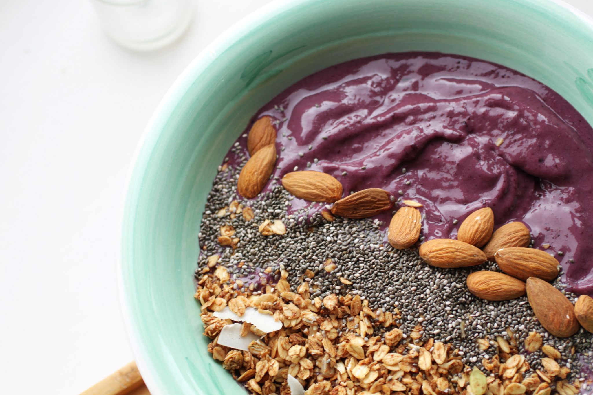 cherry and vanilla smoothie bowl topped with nuts, granola and seeds