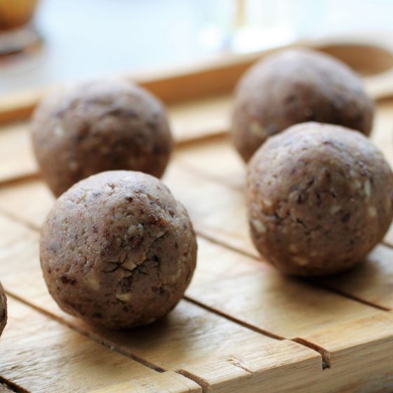 strawberry white chocolate protein balls lined up on a tray