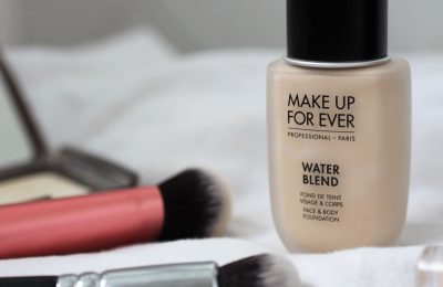 Make Up For Ever Water Blend Foundation with some brushes on a white sheet