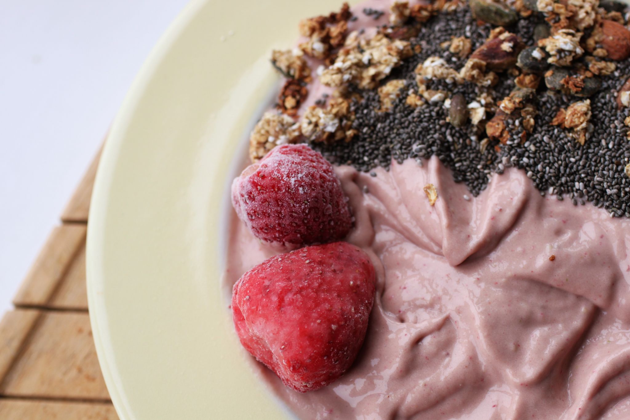 close up of the texture of the strawberries and cream smoothie bowl recipe, with toppings