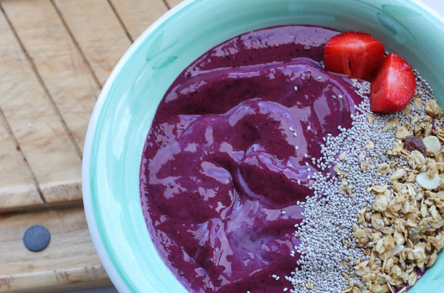 cherry smoothie bowl on a wooden board