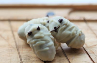 two cookie dough mummies on a wooden tray