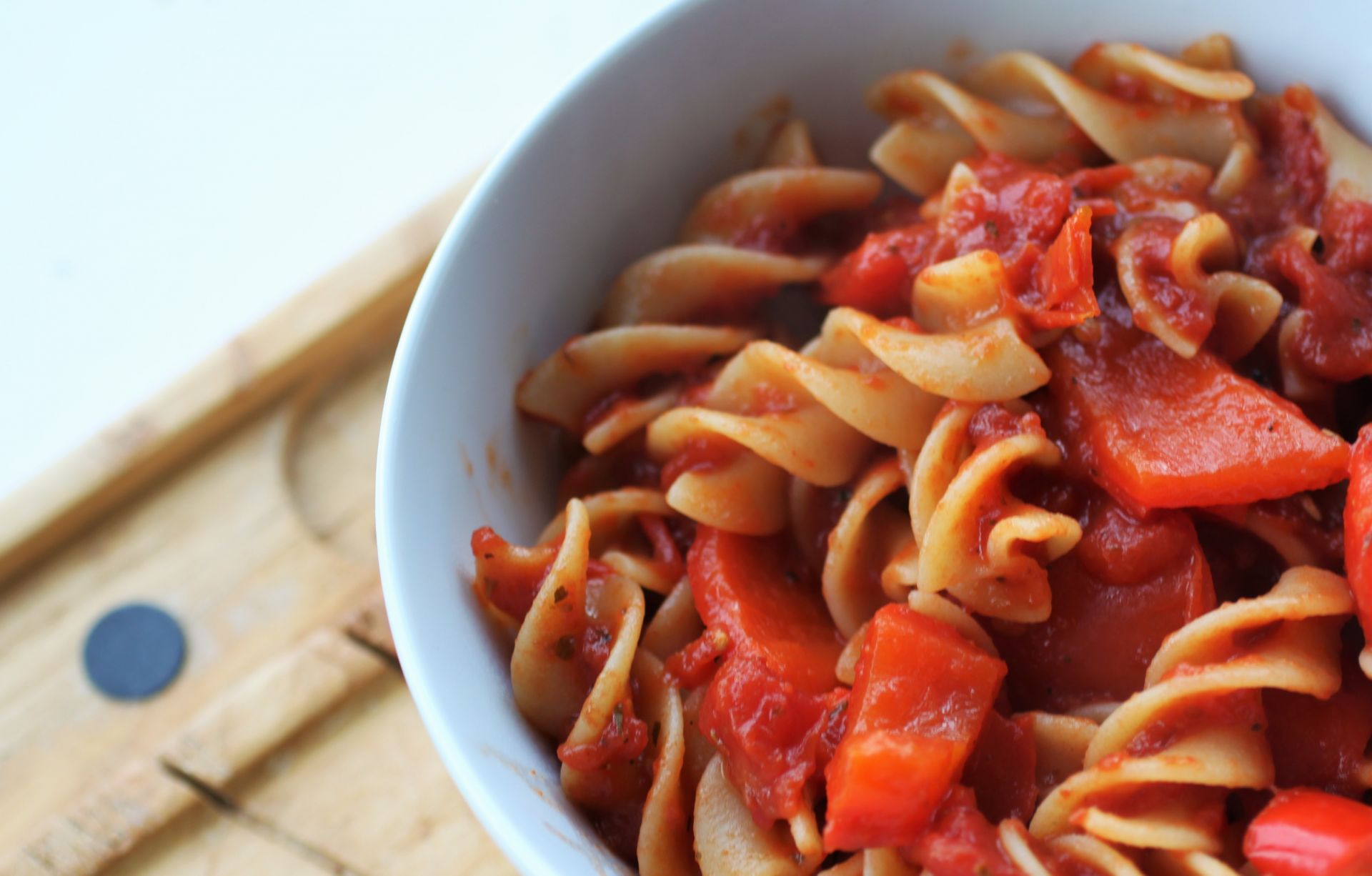 one of the best gluten free pastas - Garafolo gluten free pasta with sauce in a white bowl on a wooden tray