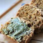 slices of vegan pumpkin loaf with pumpkin seed butter on