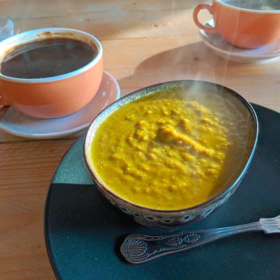 a picture of my food trying to eat out vegan and gluten free - a bowl of pea and mint soup with a cup of coffee