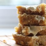 stack of vegan orange blondies with white chocolate dripping down the side