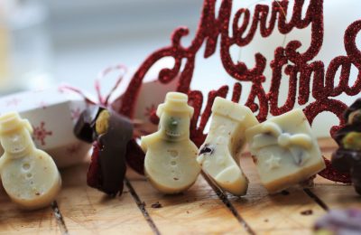vegan christmas chocolates recipe on a wooden tray with some christmas crackers and decorations