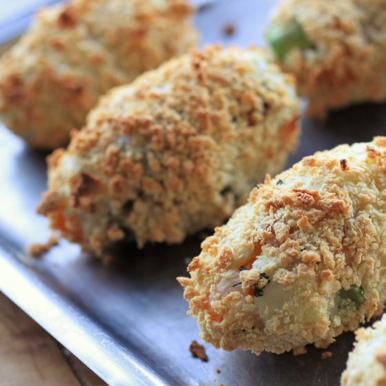 vegan winter vegetable croquettes, cooked, lined up on a baking tray