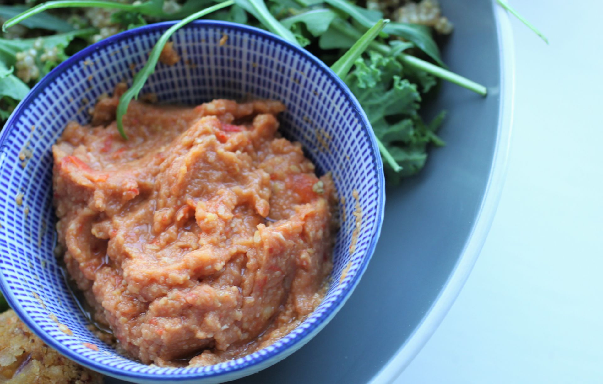 close up shot of the dip in a small round blue dish