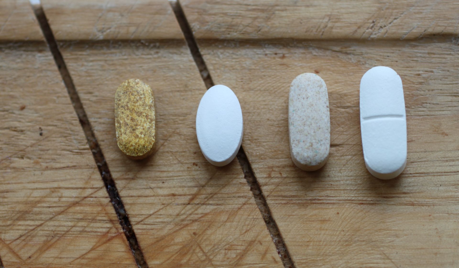 4 supplements in a straight line on a wooden board