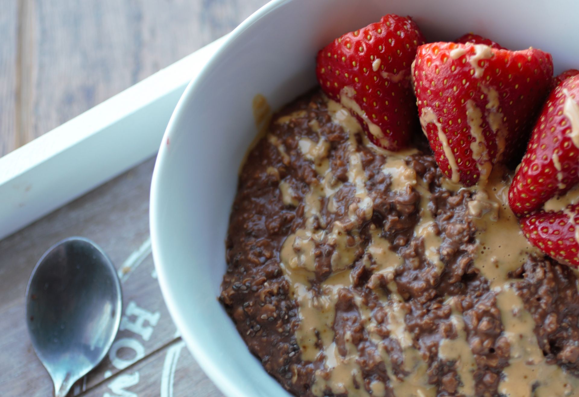 white bowl filled with chocolate oats and strawberries
