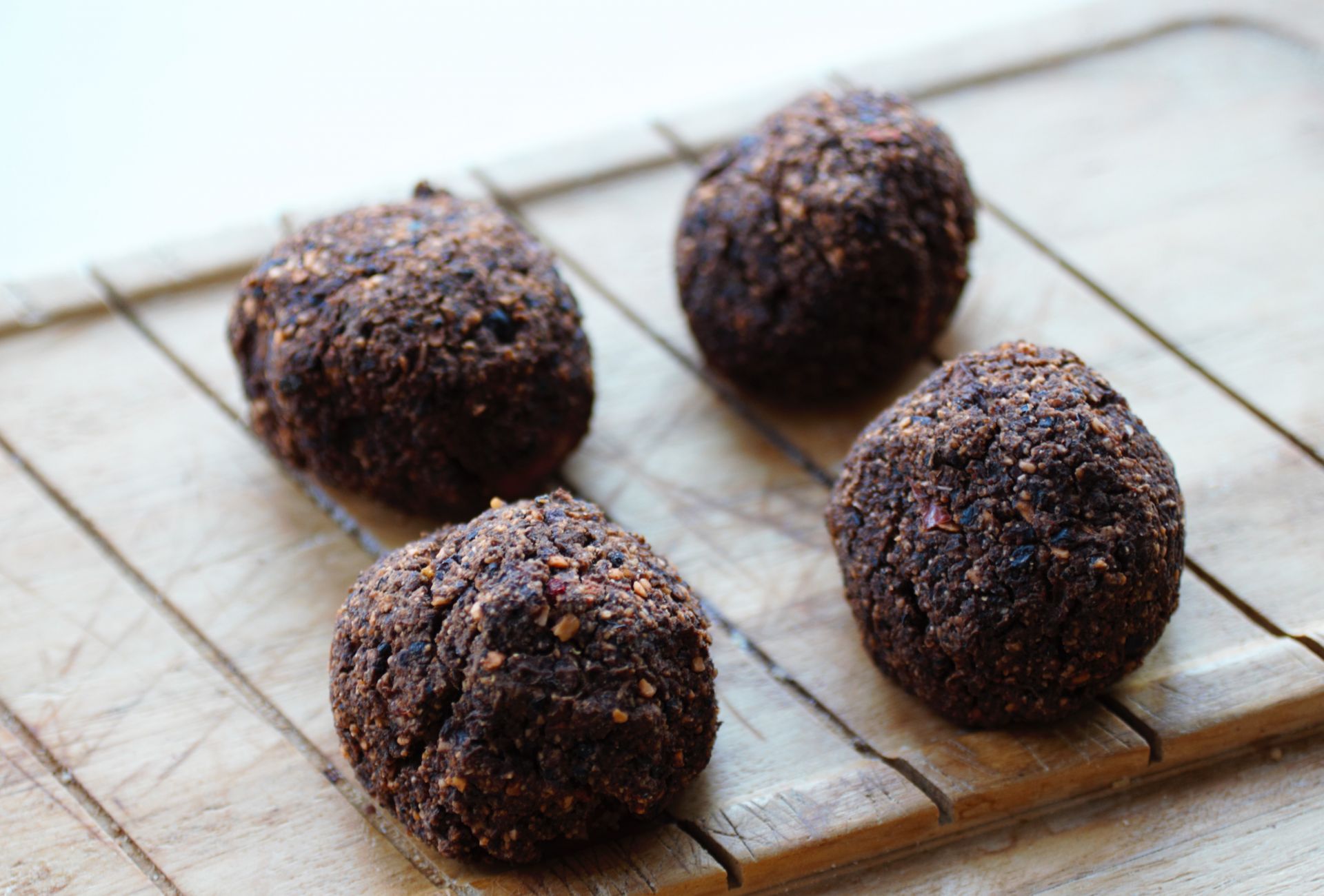 4 black bean meatballs on a wooden tray