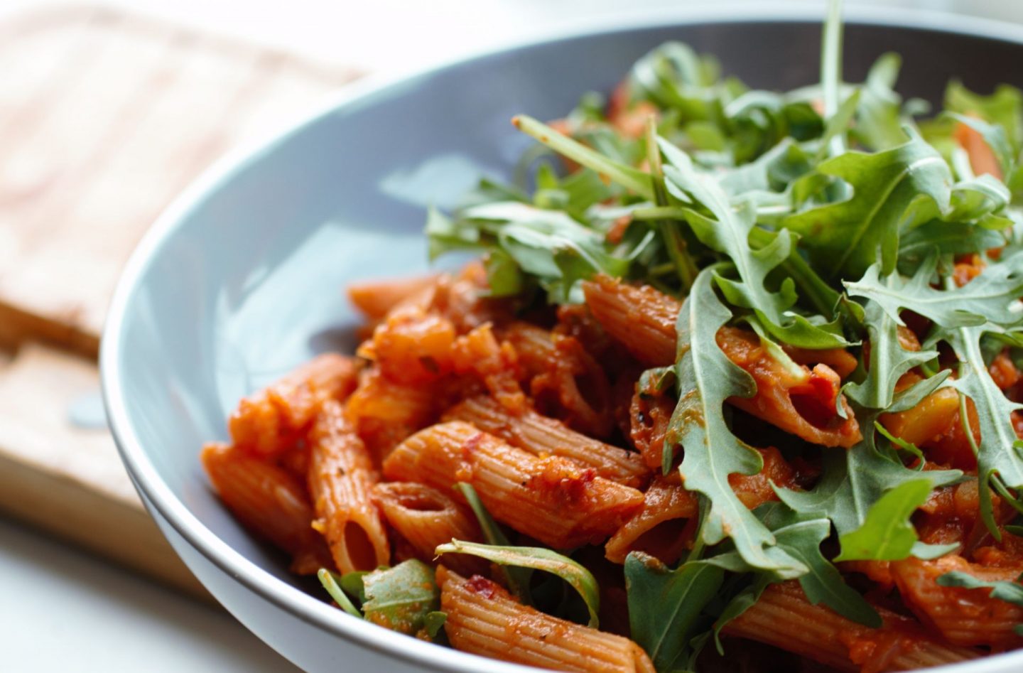 grey pasta bowl of creamy butternut squash pasta with some fresh rocket