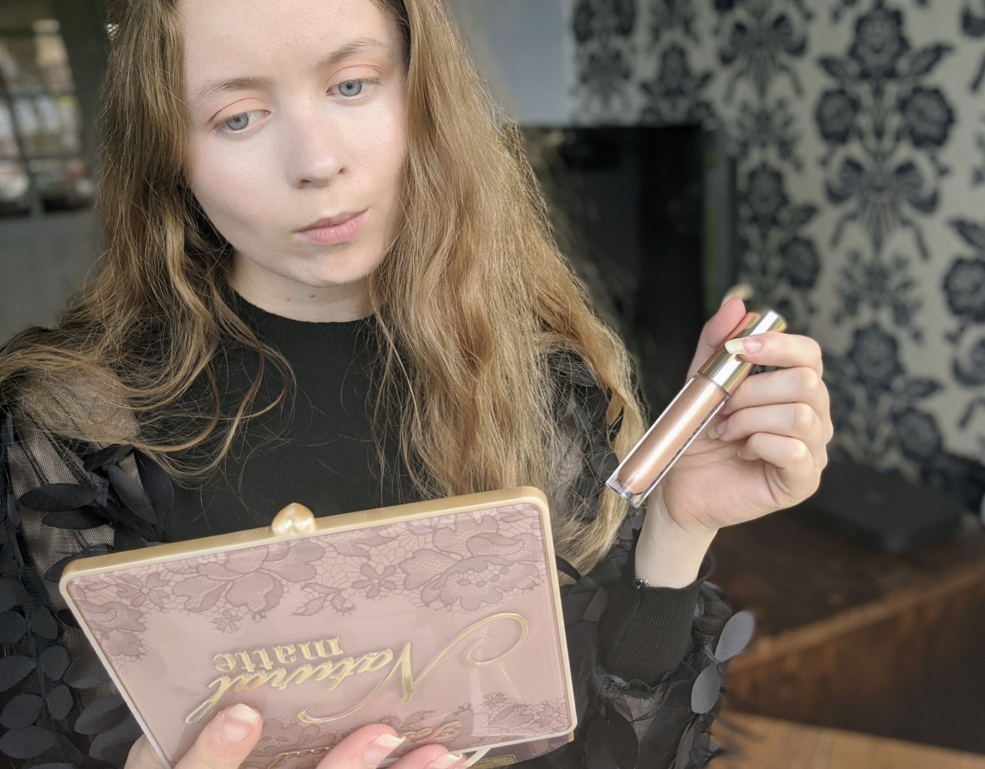 Me, sat looking in a mirror while holding a bali body highlighter stick
