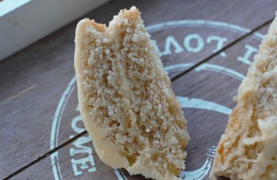two slices of vegan lemon & orange cake on a wooden tray