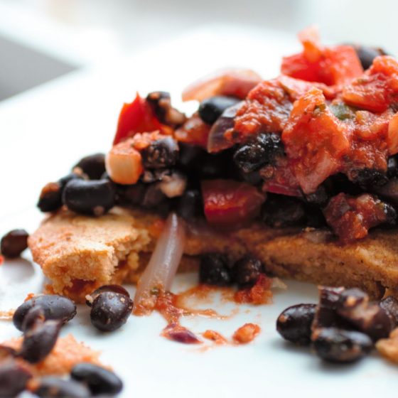 lentil flatbreads cut open with beans on a white plate