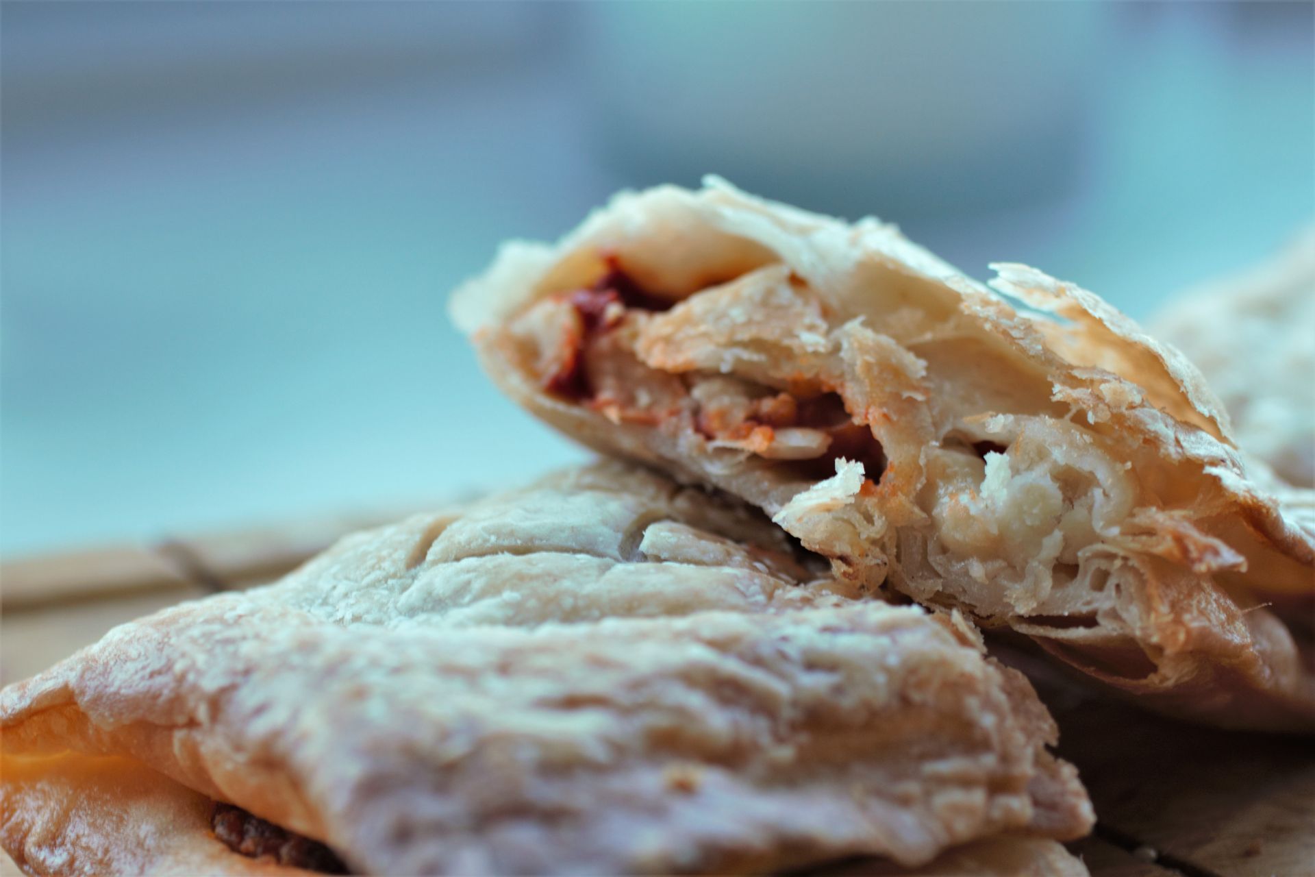 two italian bean pasties on a wooden board, one cut open to show inside