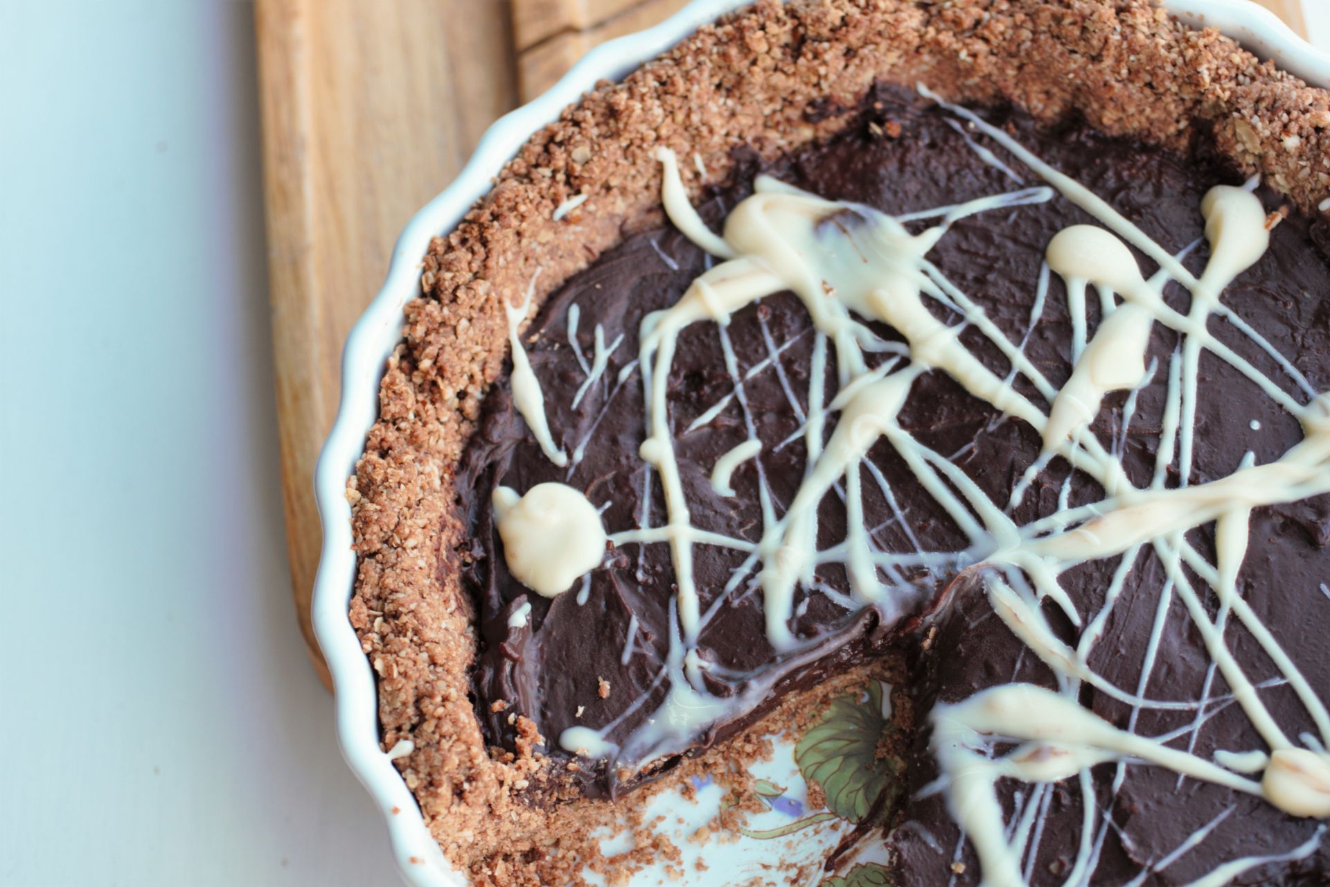 chocolate almond tart in pie dish wiht a slice takenout