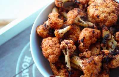 bowl of crispy baked cauliflower on a wooden tray