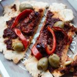 rustic gluten free flatbread sliced up on a wooden board