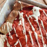 batch of cooked lentil enchiladas in a dish, placed on a wooden board