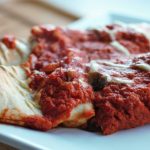 two lentil enchiladas served up on a plate