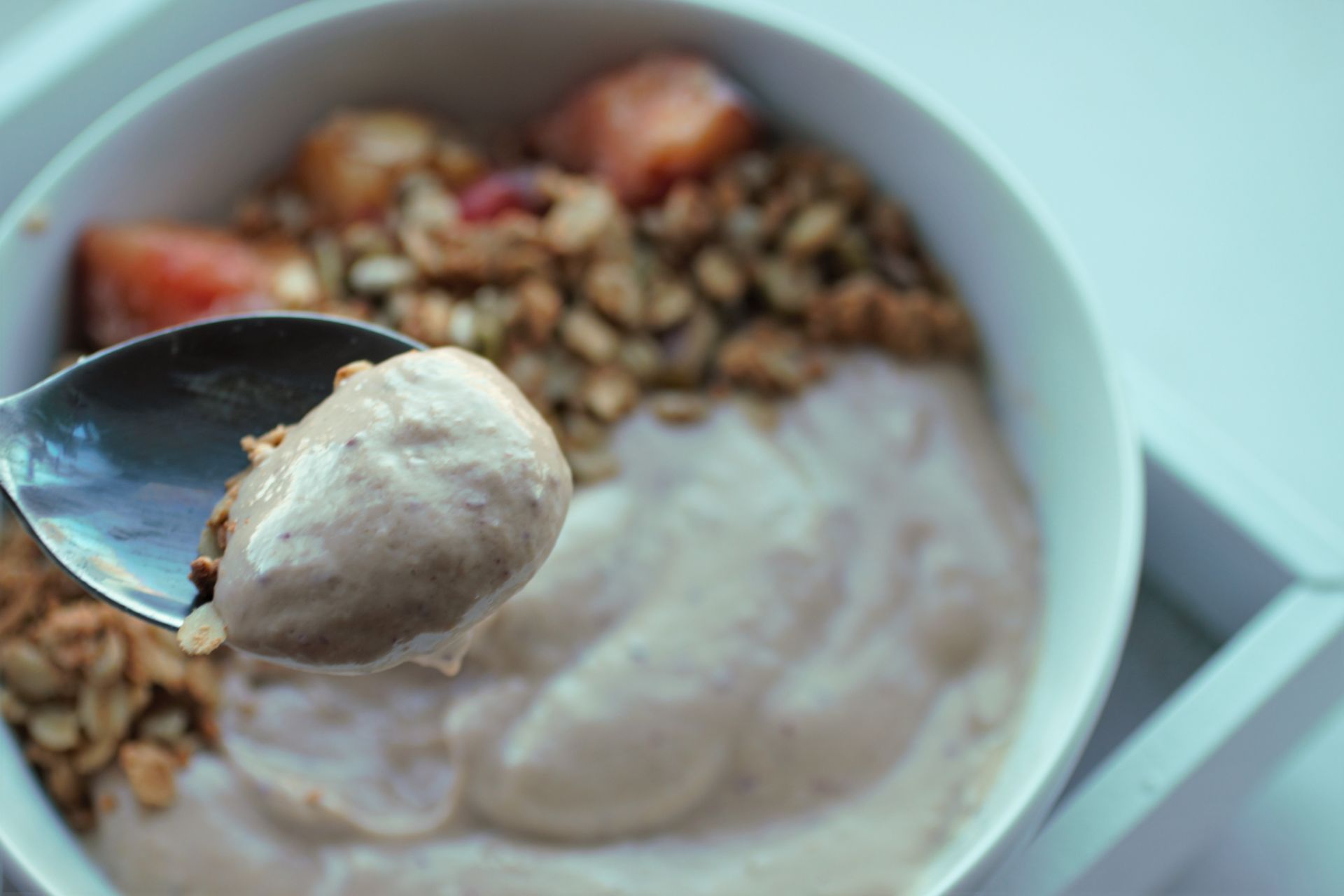 a close up of the peaches and cream smoothie on a spoon to show the creamy texture