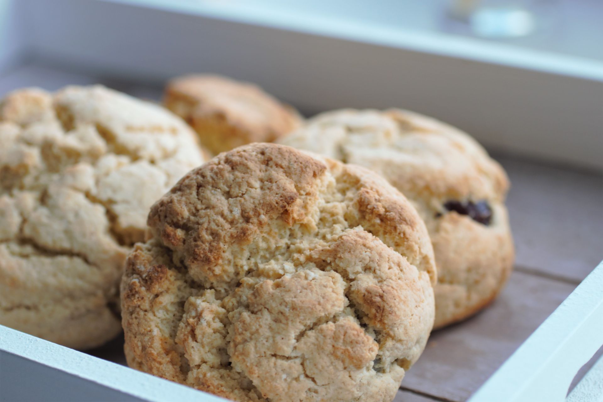 a grey wooden tray with four scones on