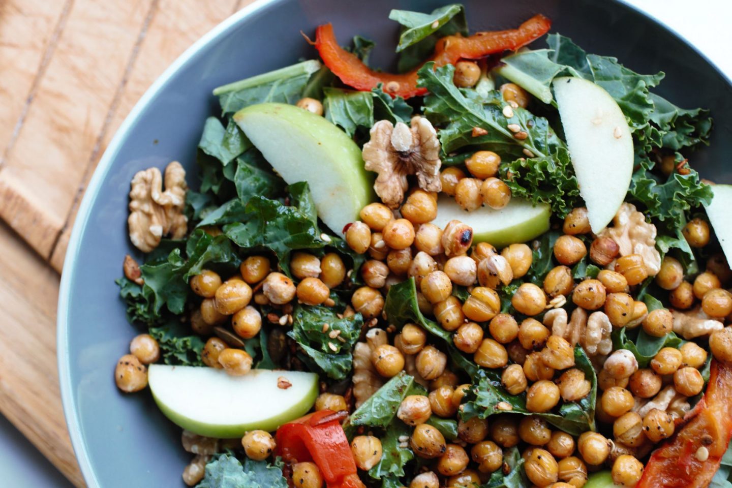 omega 3 salad recipe in a large slate coloured salad bowl, placed on a wooden bread board