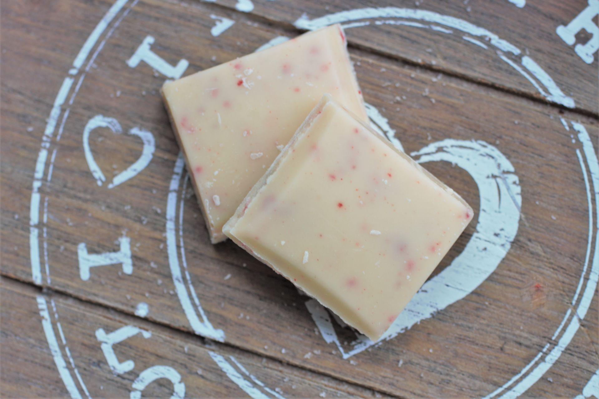 2 squares of strawberries and ceam chocolate o a wooden board