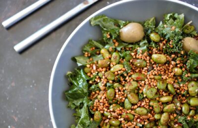 slate bowl with edamame salad in it against a dark background