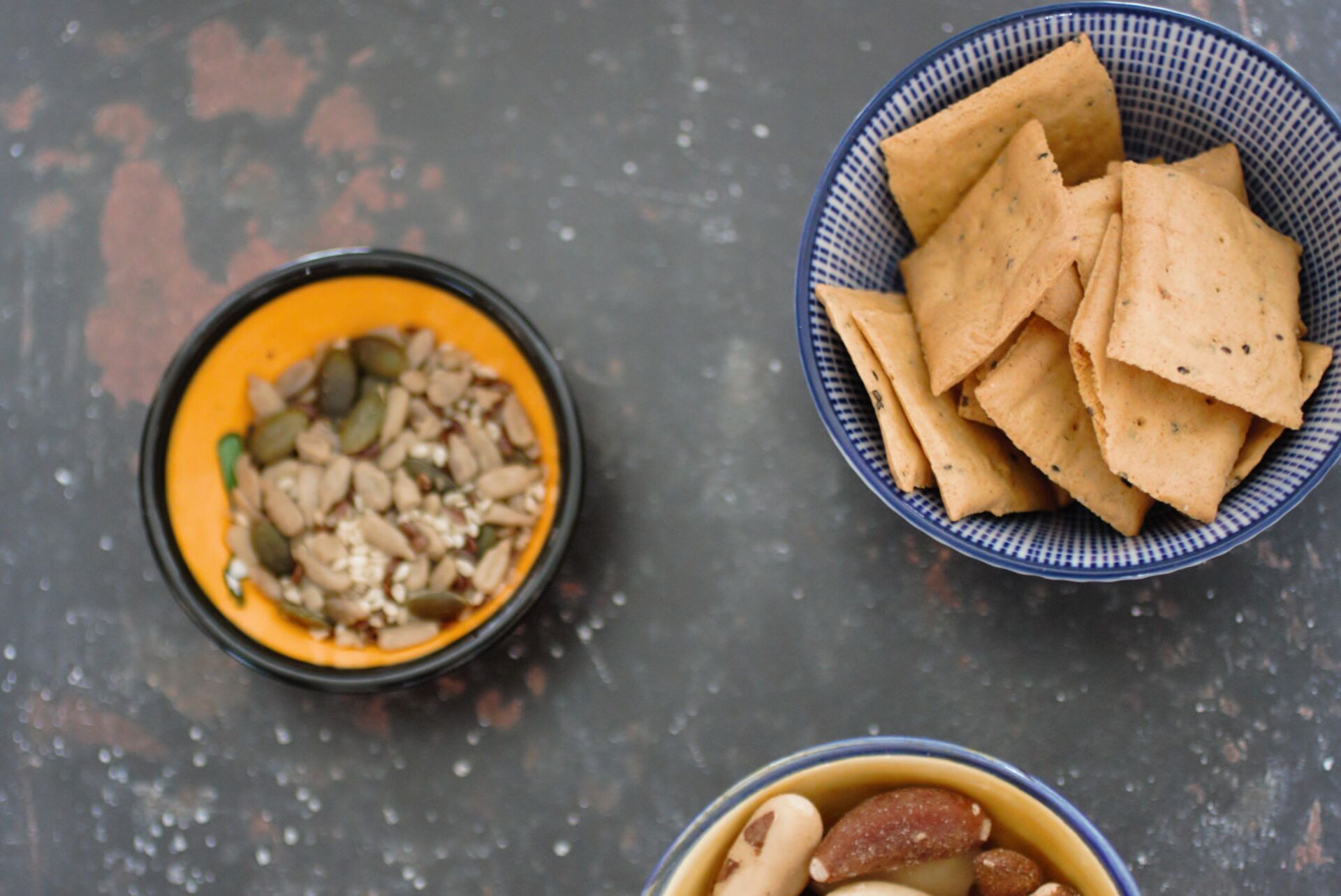 three small snack bowls against a dark background