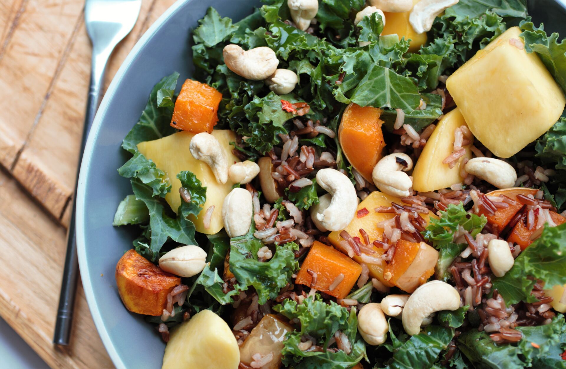 summer salad recipe in a large pasta bowl, placed on a wooden board