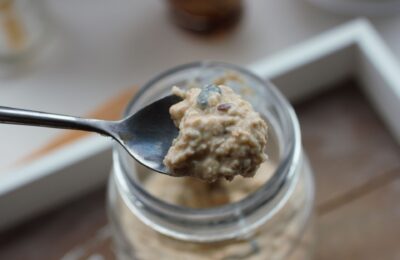 spoon of bircher muesli being raised from the jar