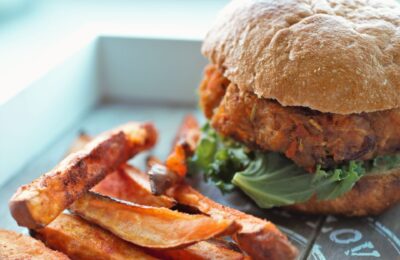 all veggie burger and sweet potato fries on a wooden board