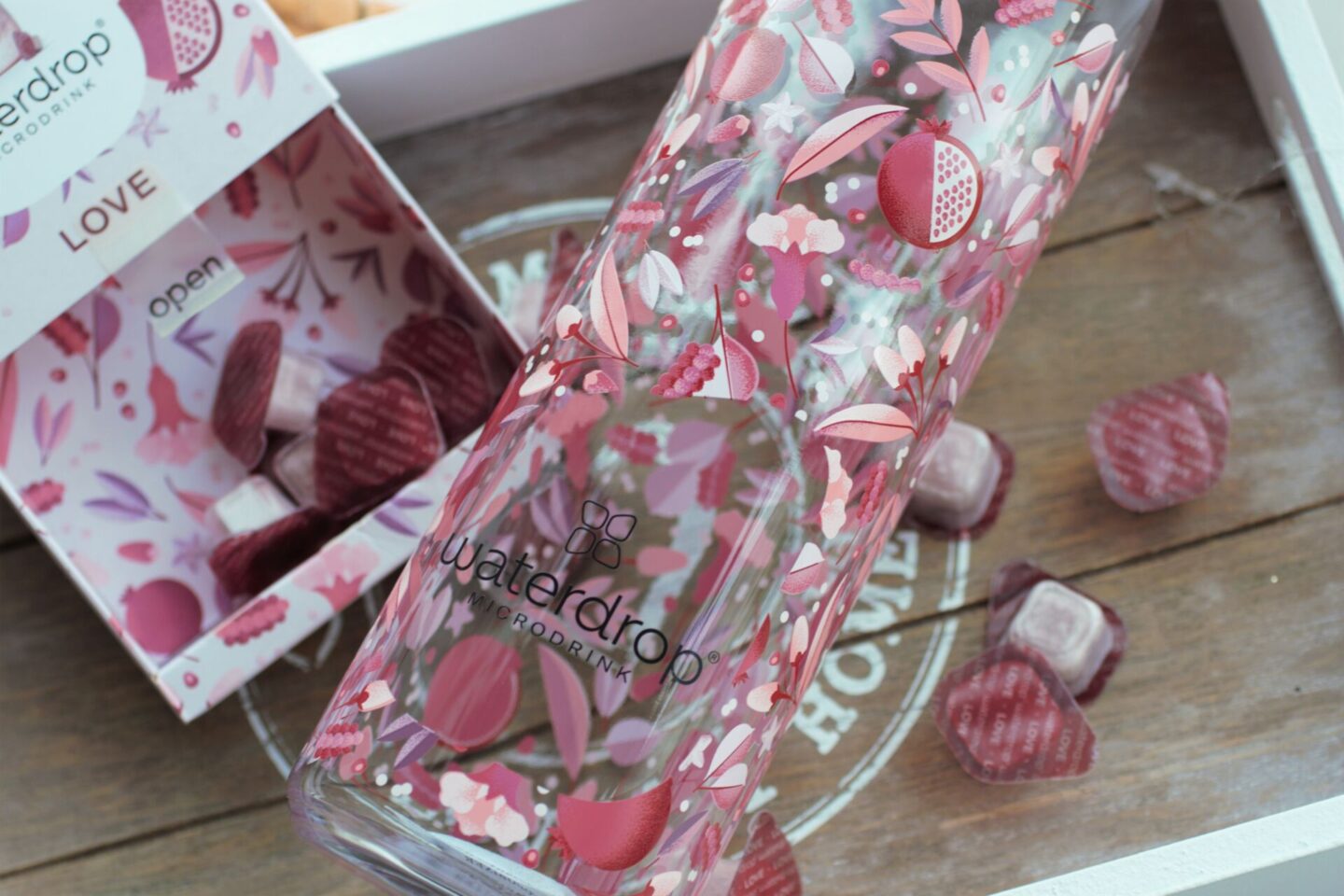 a glass water bottle on a grey tray