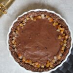chocolate orange custard pie on a grey backdrop with some Christmas crackers