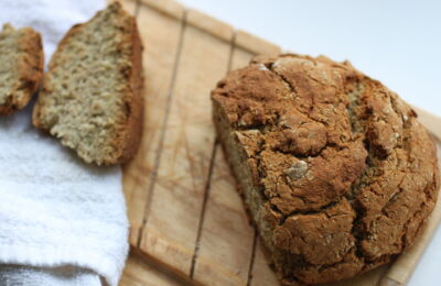 loaf shot from above, on a wooden bread board with one end sliced