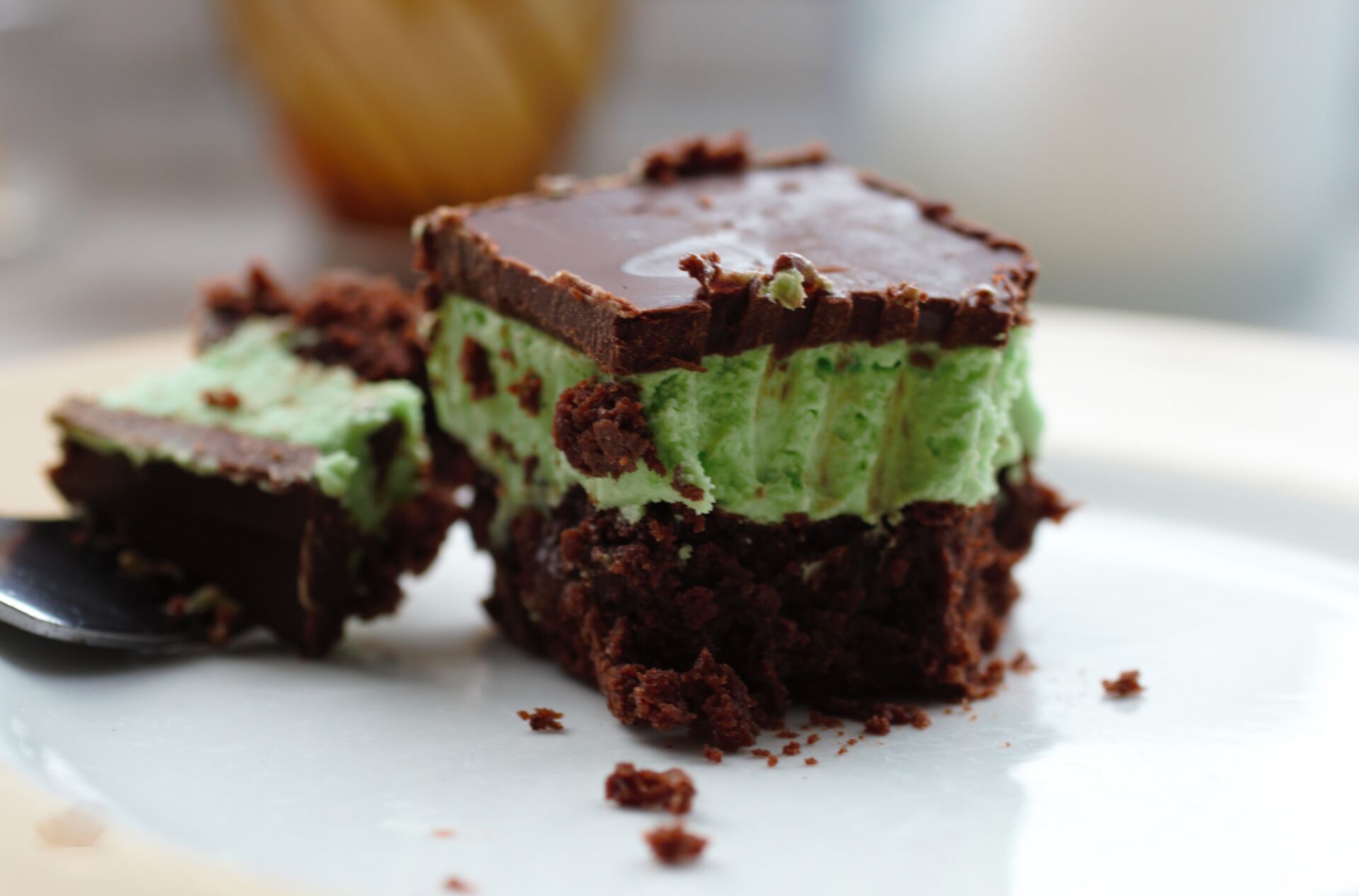 vegan mint three layer brownie on a plate with a fork next to it