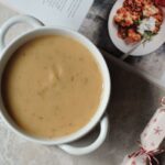 maple parsnip and potato soup in a white bowl, next to some Christmas decorations