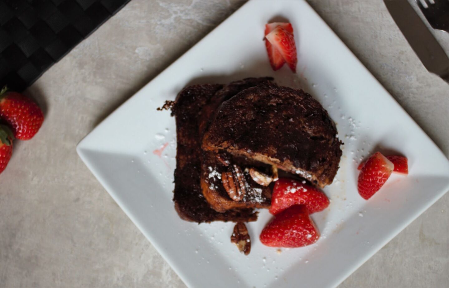 plate of chocolate French toast with berries around it, shot from above