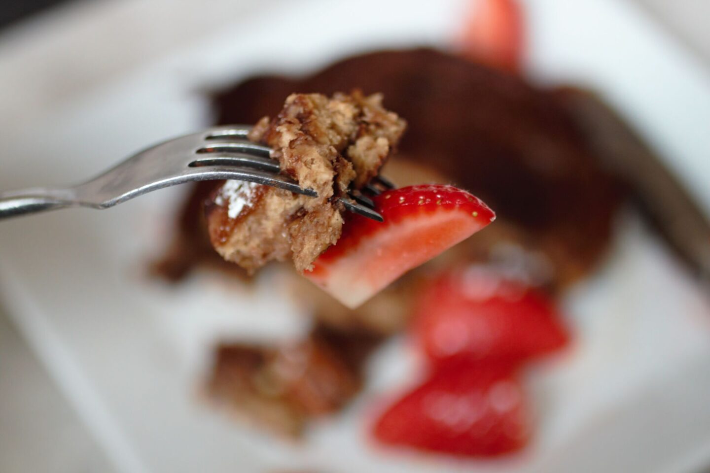 a piece of the chocolate French toast recipe on a fork with a strawberry
