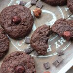 nutella cookies on a tray with some chocolate chips and hazelnuts