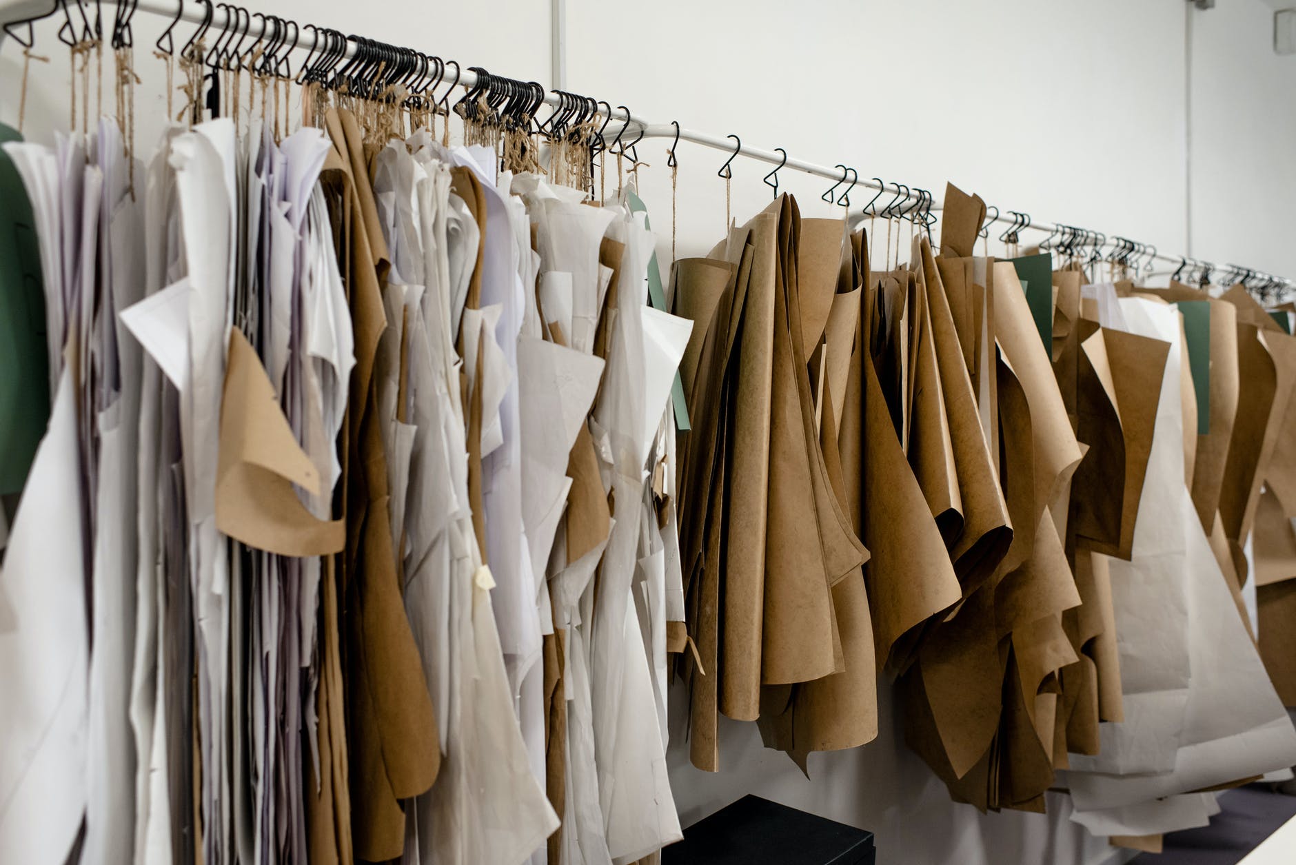 assorted sewing patterns on hangers inside tailor atelier