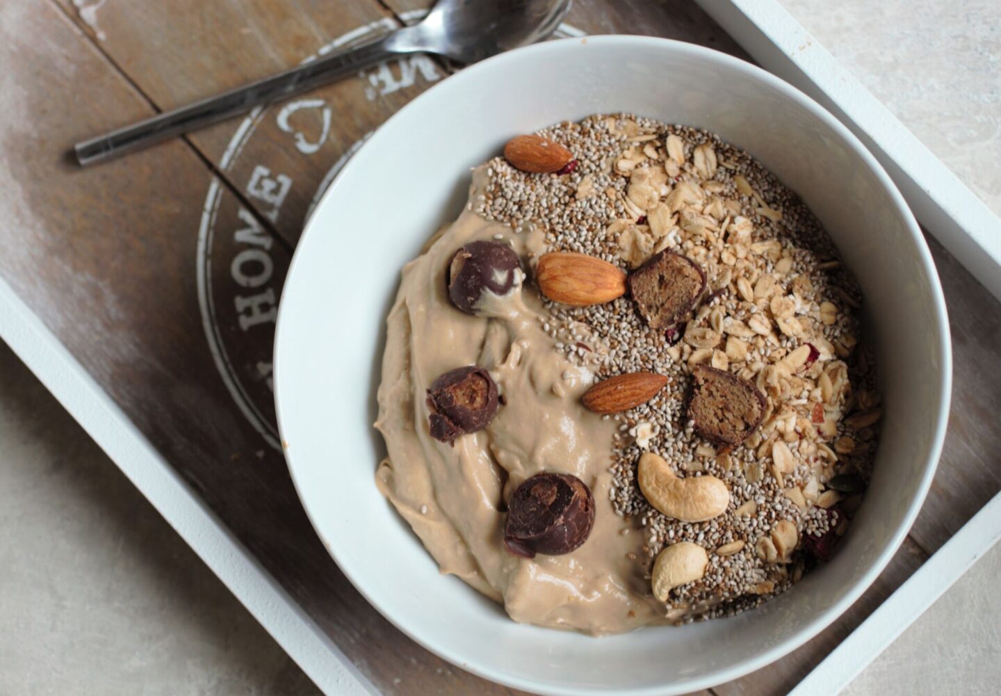 peanut butter smoothie bowl recipe in a white bowl placed on a grey tray