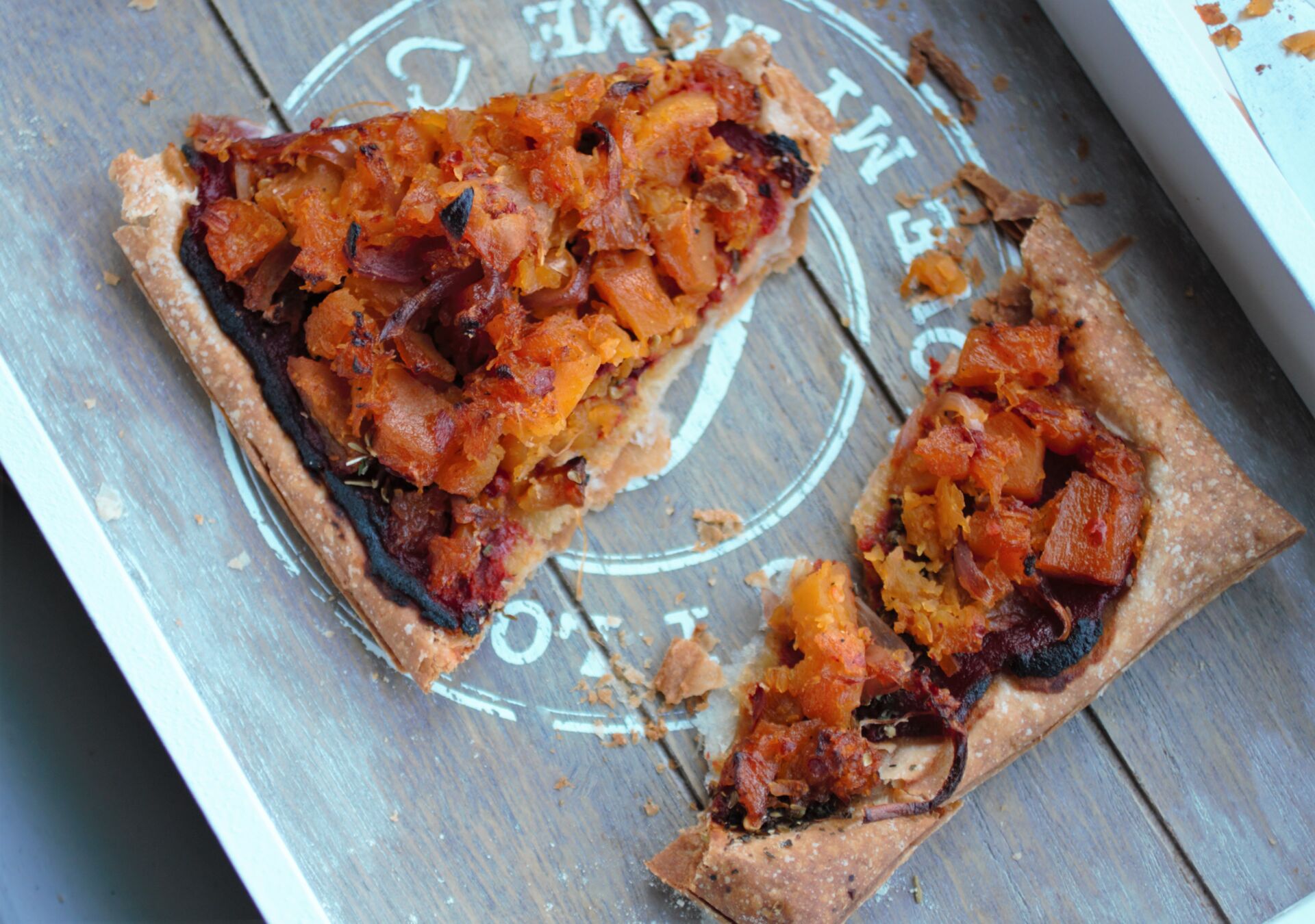 vegan caramelised squash pizza tarts sliced on a grey wooden tray