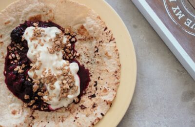 breakfast tortilla recipe topped with Greet style yoghurt, berries and a sprinkle of granola, shot from above