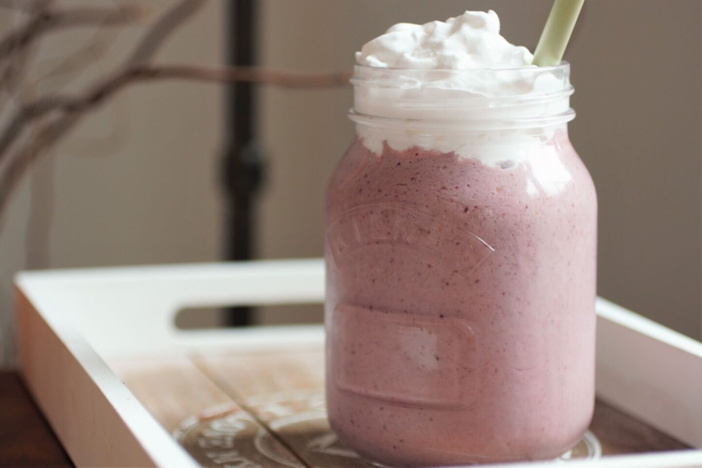 glass of cherry bakewell milkshake topped with vegan cream 